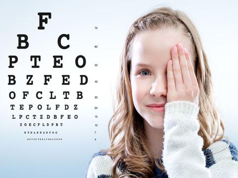 Senhora tapando um olho e lendo uma tabela com letras para determinao da acuidade visual