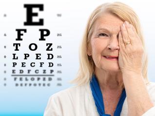 Senhora tapando um olho e lendo uma tabela com letras para determinao da acuidade visual
